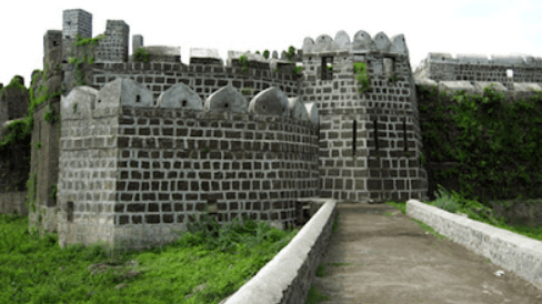 a stone castle with grass and a walkway